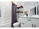 Bathroom with a shower-tub combo, modern fixtures, and stylish shelving at 4224 W Kensington Ave, Tampa, FL 33629