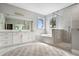 Bright bathroom with white cabinetry, soaking tub, and glass-enclosed shower at 4224 W Kensington Ave, Tampa, FL 33629