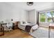 Bedroom with desk, chair, hardwood floors, and a large window for natural light at 4224 W Kensington Ave, Tampa, FL 33629