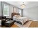 Bedroom features a large bed, cozy chair, ottoman, and bright windows at 4224 W Kensington Ave, Tampa, FL 33629