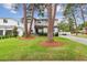 Charming two-story home featuring a lush green lawn, mature trees, and a welcoming entrance at 4224 W Kensington Ave, Tampa, FL 33629