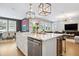 Open-concept kitchen island with sink, dishwasher, seating, and views of the dining and living areas at 4224 W Kensington Ave, Tampa, FL 33629