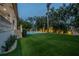 Backyard featuring a luxurious pool, lush tropical landscaping, and elegant outdoor lighting at 5020 W Dickens Ave, Tampa, FL 33629