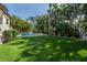 Expansive backyard featuring lush green grass and beautiful tropical landscaping surrounding the pool area at 5020 W Dickens Ave, Tampa, FL 33629