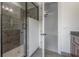 Bathroom with tiled shower, glass door, and view to bedroom with neutral carpet at 5020 W Dickens Ave, Tampa, FL 33629