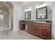 Elegant bathroom boasts rich wood cabinets, dark green marble countertops, and a luxurious glass enclosed shower at 5020 W Dickens Ave, Tampa, FL 33629