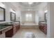 Bright bathroom featuring double vanities, a large soaking tub, and a decorative tiled floor at 5020 W Dickens Ave, Tampa, FL 33629