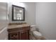 Well-lit half bathroom featuring a dark wood vanity with a granite countertop at 5020 W Dickens Ave, Tampa, FL 33629