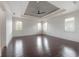 Expansive bedroom with hardwood floors, a tray ceiling, and abundant natural light from the shuttered windows at 5020 W Dickens Ave, Tampa, FL 33629
