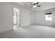 Bright bedroom with neutral carpet, ceiling fan, two closets, and entry to bath with window at 5020 W Dickens Ave, Tampa, FL 33629