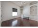 Bright bedroom featuring dark hardwood floors, built-in shelving, and a window with a gray shade at 5020 W Dickens Ave, Tampa, FL 33629