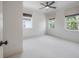 Airy bedroom features three windows, a ceiling fan, and neutral carpeting at 5020 W Dickens Ave, Tampa, FL 33629