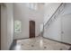 Bright foyer with a grand staircase, high ceilings, and travertine tile floors with black accents at 5020 W Dickens Ave, Tampa, FL 33629