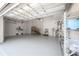 Spacious three car garage with epoxy flooring, utility sink, and storage shelving at 5020 W Dickens Ave, Tampa, FL 33629