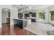 Open kitchen featuring white stone floors, black cabinets, marble countertop, and modern lighting fixtures at 5020 W Dickens Ave, Tampa, FL 33629