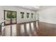Bright living room with hardwood floors, three windows, and a set of glass doors at 5020 W Dickens Ave, Tampa, FL 33629
