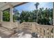Covered patio featuring stone balustrade overlooking the lush yard and tropical landscaping at 5020 W Dickens Ave, Tampa, FL 33629