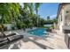 Inviting backyard pool and patio area surrounded by lush tropical landscaping and comfortable lounge furniture at 5020 W Dickens Ave, Tampa, FL 33629