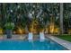 Tranquil pool area with lounge chairs, lush tropical landscaping, and clear blue water at 5020 W Dickens Ave, Tampa, FL 33629