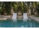 Inviting in-pool chaise lounges provide a serene setting surrounded by tropical foliage at 5020 W Dickens Ave, Tampa, FL 33629