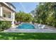 Beautiful pool with in-water loungers, surrounded by lush tropical landscaping and well-manicured lawn at 5020 W Dickens Ave, Tampa, FL 33629