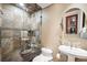 This bathroom has unique tiling, a glass shower door, and a pedestal sink creating a clean and elegant look at 513 Suwanee Cir, Tampa, FL 33606