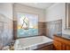 Bathroom with white tub and sailboat-themed stained glass window at 513 Suwanee Cir, Tampa, FL 33606