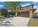 Two-story house featuring an arched entryway and a large driveway, surrounded by mature trees at 513 Suwanee Cir, Tampa, FL 33606