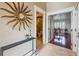 Inviting foyer with travertine floors, decorative sunburst mirror, and views into the bathroom and office at 513 Suwanee Cir, Tampa, FL 33606
