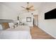Bright main bedroom featuring a ceiling fan, wood floors, and a wall-mounted television at 513 Suwanee Cir, Tampa, FL 33606
