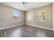 Neutral bedroom featuring a ceiling fan and wood-look floors, illuminated by two large windows at 5130 Dr Martin Luther King Jr St S, St Petersburg, FL 33705