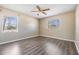 Neutral bedroom featuring a ceiling fan and wood-look floors, illuminated by two large windows at 5130 Dr Martin Luther King Jr St S, St Petersburg, FL 33705