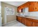 A simple kitchen area featuring a double sink, older cabinets, and basic appliances at 5130 Dr Martin Luther King Jr St S, St Petersburg, FL 33705
