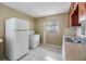 A simple kitchen area featuring a double sink, older cabinets, and basic appliances at 5130 Dr Martin Luther King Jr St S, St Petersburg, FL 33705
