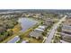Aerial view of a neighborhood with pond, showing well-manicured lawns and mature trees at 5720 107Th E Ter, Parrish, FL 34219