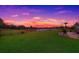 Expansive backyard with lush green grass, complemented by a tranquil water view at sunset at 5720 107Th E Ter, Parrish, FL 34219