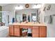 Spacious bathroom with dual sinks, a large mirror, and a tub with an organized walk-in closet in view at 5720 107Th E Ter, Parrish, FL 34219