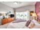 Bright bedroom featuring a large window, complemented by a wooden dresser and neutral walls at 5720 107Th E Ter, Parrish, FL 34219