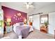 Well-lit bedroom featuring a distinctive purple accent wall, a barn door, and neutral décor at 5720 107Th E Ter, Parrish, FL 34219