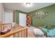 Charming Bedroom room featuring a white closet door and a whimsical Gathering tree decal on a green wall at 5720 107Th E Ter, Parrish, FL 34219