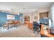 Large room with a blue accent wall, tile flooring, and ample space for both dining and a home office setup at 5720 107Th E Ter, Parrish, FL 34219