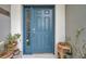 Stylish blue front door with sidelight window and decorative potted plants creating a welcoming entrance at 5720 107Th E Ter, Parrish, FL 34219