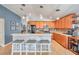 Bright kitchen design features wood cabinets, stainless steel appliances, breakfast bar, and ample counter space at 5720 107Th E Ter, Parrish, FL 34219