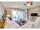 The living room has wood accent wall, tile floors, modern ceiling fan, and a large sectional sofa at 5720 107Th E Ter, Parrish, FL 34219