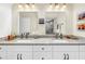 Bright bathroom featuring double sinks, granite countertops, modern fixtures, and decorative mirrors and artwork at 6093 Bahia Del Mar Cir # 375, St Petersburg, FL 33715
