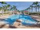 Spacious community pool with ample seating surrounded by lush palm trees at 6093 Bahia Del Mar Cir # 375, St Petersburg, FL 33715