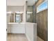Bright bathroom with double vanity, modern fixtures, and a walk-in shower with neutral tile at 2416 Wise River Ln, Zephyrhills, FL 33541