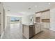 A modern, open-concept kitchen featuring stainless steel appliances, an island, and lots of natural light at 2416 Wise River Ln, Zephyrhills, FL 33541