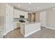 Modern kitchen features stainless steel appliances, white cabinetry, an island, and stylish tile backsplash at 2416 Wise River Ln, Zephyrhills, FL 33541