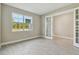 Bright room with neutral walls, wood-look tile flooring, and a large window with views of trees at 2416 Wise River Ln, Zephyrhills, FL 33541